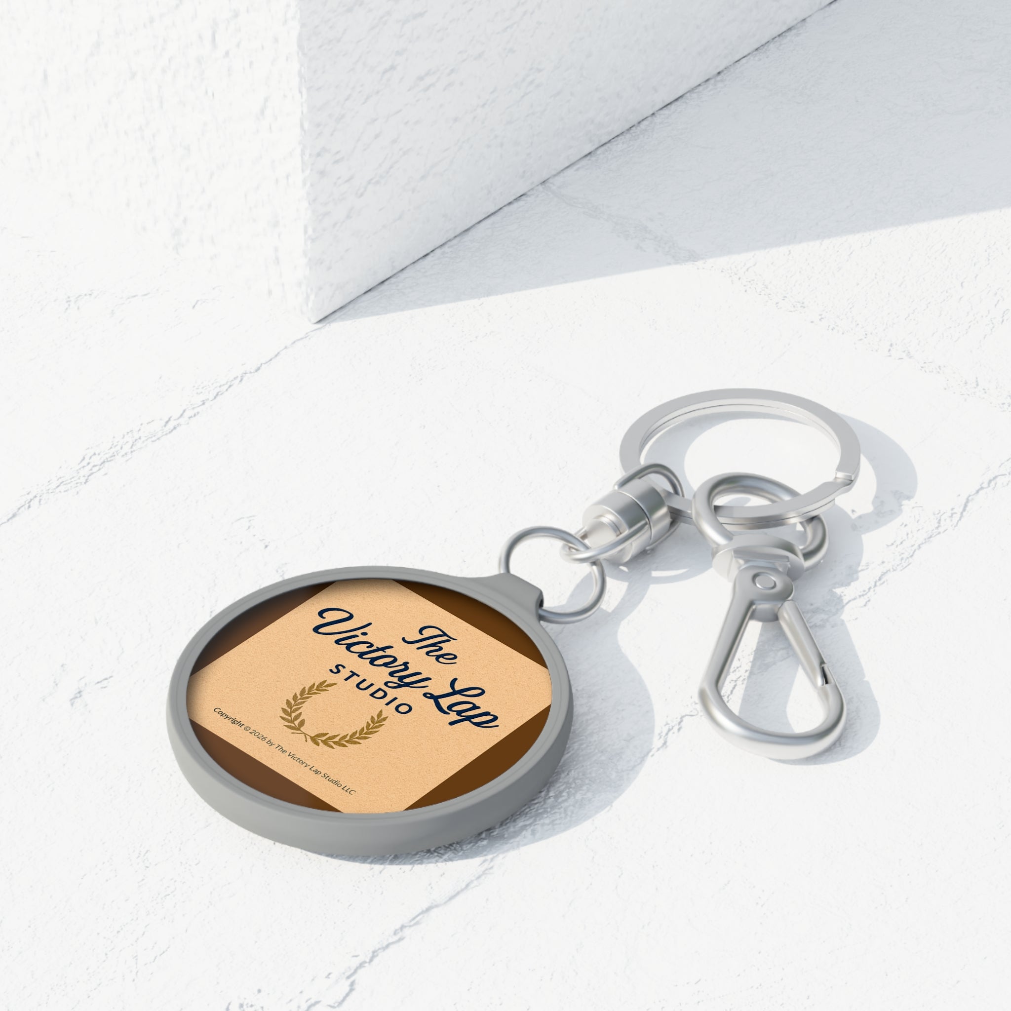 Sleutelhanger-etiket — "The Victory Lap Studio" Ronde Sleutelhanger